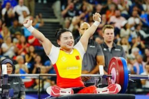 Powerlifting athlete competing in the 2024 Paralympics at Pierre de Coubertin Stadium, Paris.